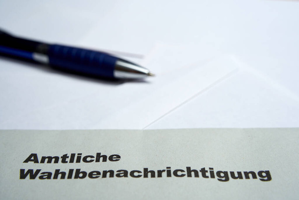 Czarne litery na białej kopercie: Oficjalne powiadomienie o wyborach (niem. Amtliche Wahlbenachrichtigung). 2021 wybory federalne w Niemczech. Niebieski długopis głębokość pola. Zbliżenie. - Zdjęcie, obraz