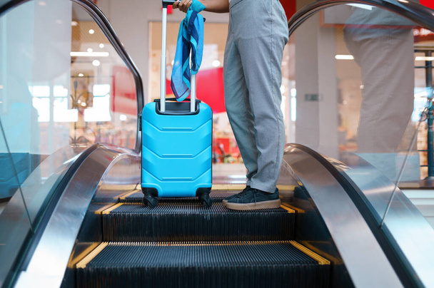 Young woman with suitcase on escalator in airport. Female person with luggage, international air gate, passenger with bag. Happy girl with baggage - Foto, Bild