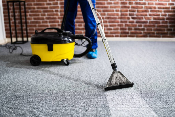Janitor Cleaning Carpet With Vacuum Cleaner At Home - Foto, Imagen