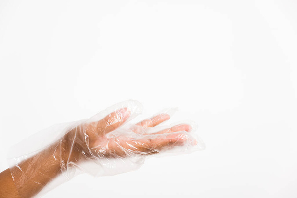 Woman hand wearing single use protect disposable transparent plastic glove, studio shot isolated on white background - Foto, Bild