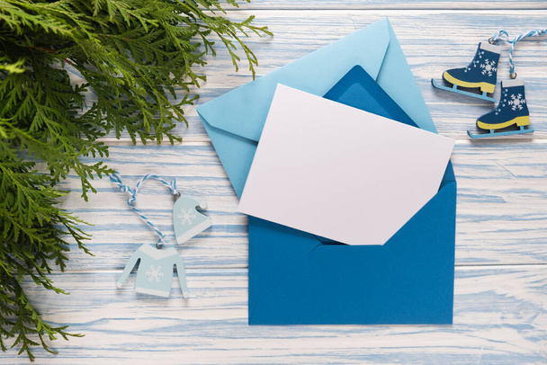 Empty Christmas card, gifts and fir branches on blue wooden background. Mockup for seasonal greetings. Space for text. - Φωτογραφία, εικόνα