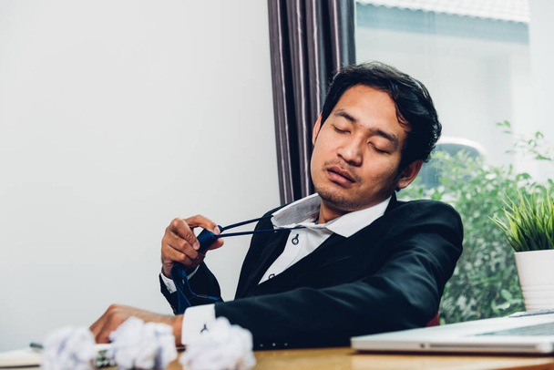 jong aziatische zakenman manager gefrustreerd hij heeft moe na het werk lange tijd - Foto, afbeelding