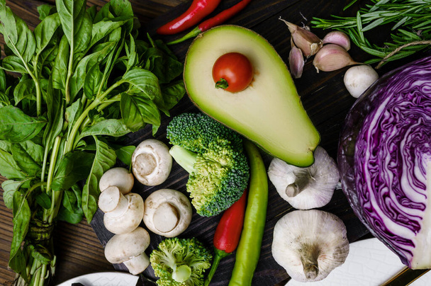 Fresh vegetables and avocado closeup, on wooden background. Organic vegetarian food, grocery assortment, natural products, healthy lifestyle concept - Fotó, kép