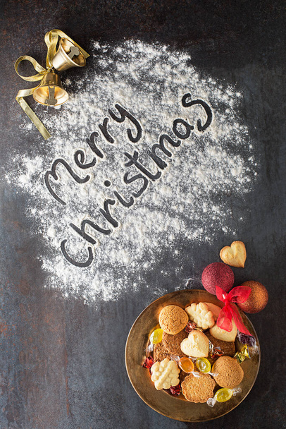 Merry Christmas text made with flour with decorations objects and cookies. Christmas, winter, new year concept background. - Фото, зображення