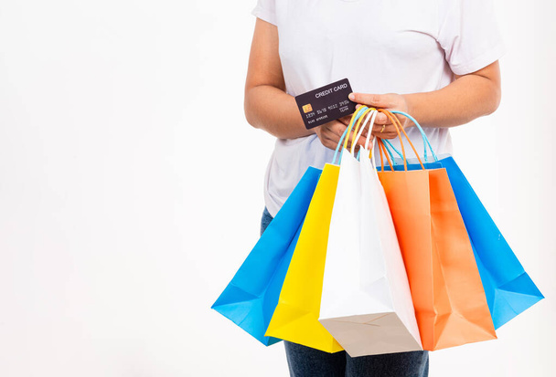 幸せな女性の手を保持ショッピングバッグ多色とクレジットカード用ショッピングオンライン、若い女性は多くのパケットを保持腕の中に隔離された白い背景、黒金曜日販売コンセプト - 写真・画像