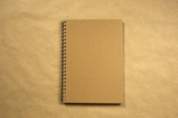 recycled brown paper blank notebook front cover with brown background texture top view, copy space, space for text modern design, business or education concept vintage - Photo, Image