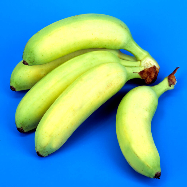 fresh ripe bananas on a blue background - Foto, afbeelding