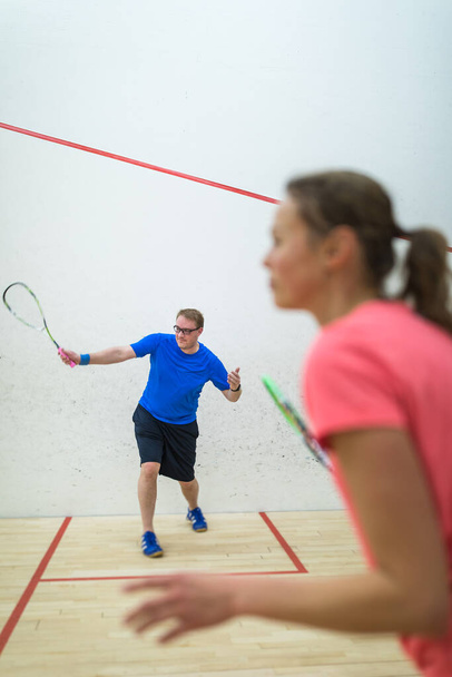 Squash players in action on a squash court (motion blurred image  color toned image) - 写真・画像
