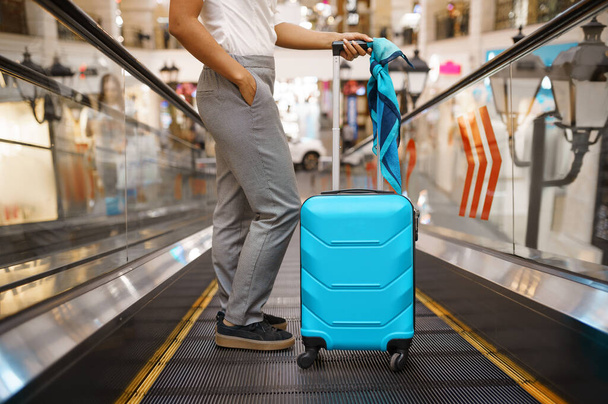 空港のエスカレーターにスーツケースを着た若い女性。荷物を持つ女性の人、国際航空ゲート、バッグ付きの乗客。荷物のある幸せな女の子 - 写真・画像