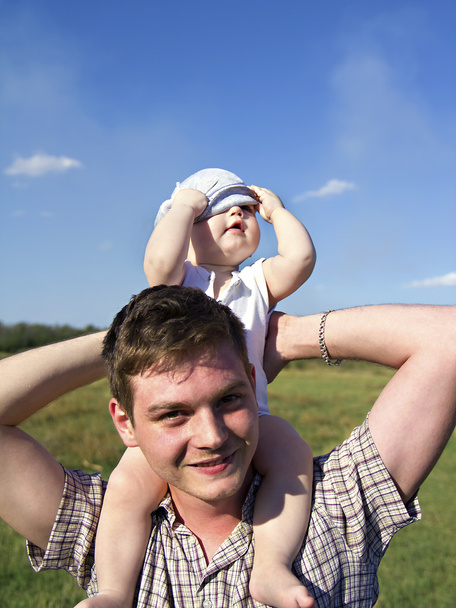pai segura uma criança pequena em seus ombros
 - Foto, Imagem