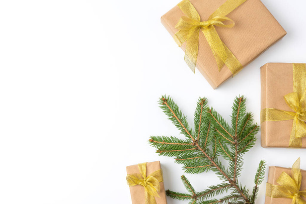gift boxes wrapped in brown paper and tied with a golden ribbon on a white background, top view, copy space - Φωτογραφία, εικόνα