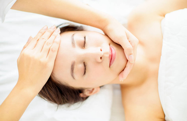 relaxed beautiful Young woman enjoy massage in spa salon - Foto, imagen