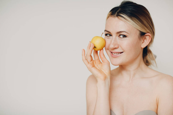 Jeune belle femme avec pomme près du visage, la jeunesse et la peau cosmétiques de soins naturels concept - Photo, image