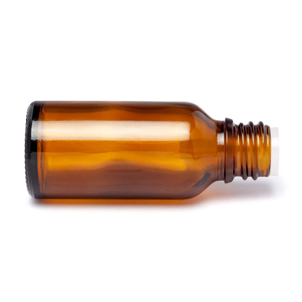 Amber color small glass bottle with pin hole dropper and black cap. - Foto, imagen