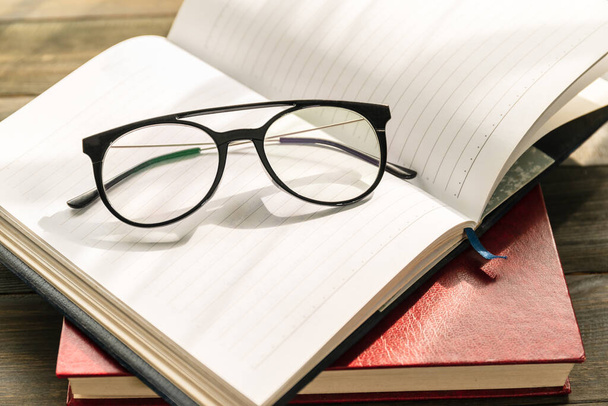 book and glasses on wooden table - Foto, Imagen