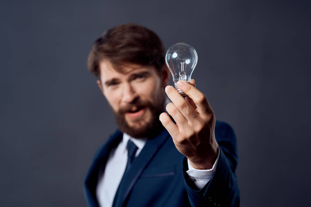 homme en costume tenant une lampe idée succès innovation - Photo, image