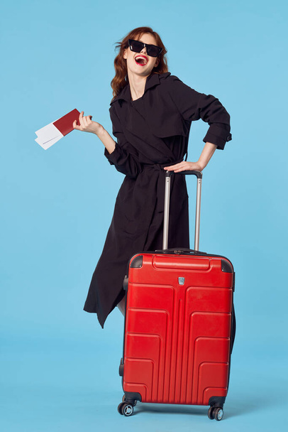 γυναίκα με μαύρο παλτό αποσκευές διαβατήριο αεροπορικά εισιτήρια επαγγελματικό ταξίδι - Φωτογραφία, εικόνα