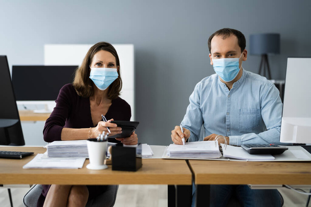 Chartered Tax Accountants With Calculators In Face Masks - Foto, Imagen