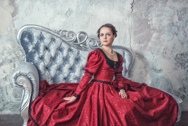 szép nő, középkori ruhában a kanapén - Fotó, kép