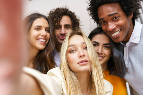 Groupe multi-ethnique d'amis prenant un selfie ensemble tout en s'amusant à l'extérieur. - Photo, image