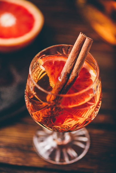 Whisky all'arancia rossa cocktail acido con bourbon invecchiato, succo d'arancia rosso sangue, sciroppo di ciliegie e cannella - Foto, immagini