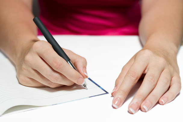 Las manos de la mujer sosteniendo una pluma escribiendo un texto
 - Foto, imagen