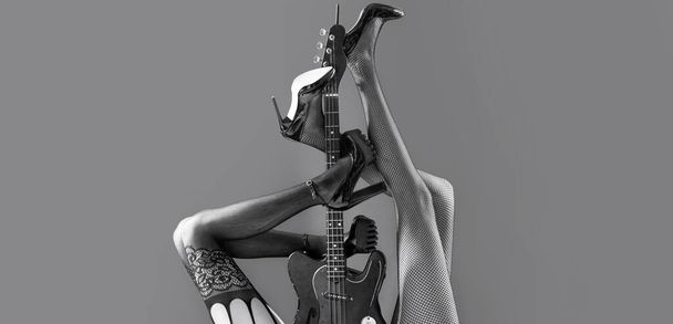 Music concept. Sexy legs. Guitar, electric guitar. Music festival, live music, concert. Instrument on stage and band. Fetish, sexy woman, electric guitar and legs, underwear. Fetish lingerie - Photo, Image