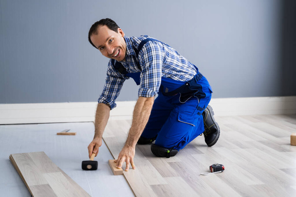 Hardwood Floor Renovation. Construction Worker Doing New Laminate Installation - Fotoğraf, Görsel