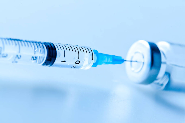 syringe with a blue background - 写真・画像