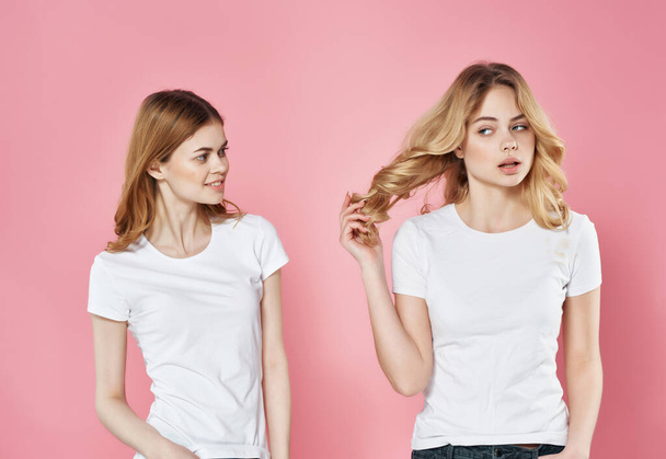 Beyaz tişörtlü iki tatlı kız arkadaş. Duygular, arkadaşlık modası. - Fotoğraf, Görsel