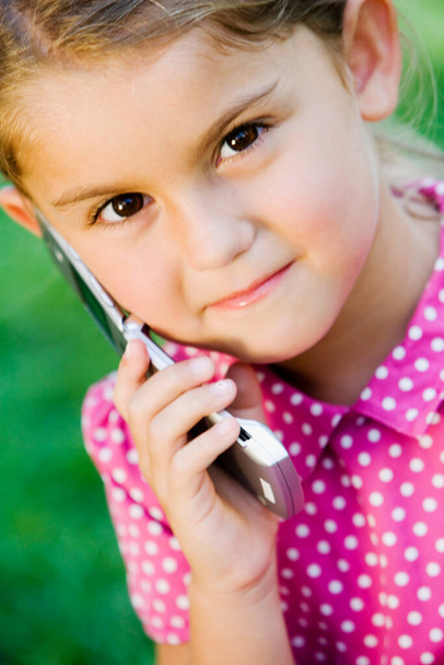 portrait of a cute little girl with a phone - Fotó, kép