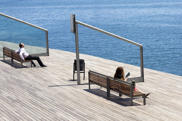 couple sitting on the pier on the beach - Foto, Imagen