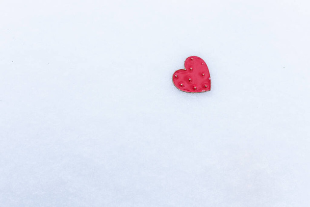 Red heart lies in the snow, Valentine's Day holiday concept, space for an inscription - Foto, afbeelding