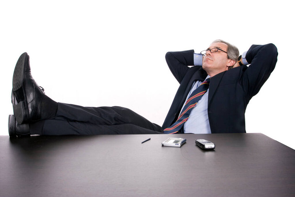 Uomo d'affari di successo che si rilassa sulla scrivania, isolato su sfondo bianco
 - Foto, immagini