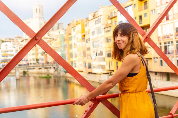 Girona medieval city, a young woman on the famous red bridge Pont de les Peixateries Velles, Costa Brava of Catalonia - Fotografie, Obrázek