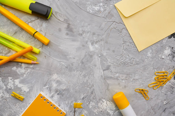 Office stationery supplies in yellow tones closeup, marble background. School or education accessories, writing and drawing tools, pencils and rubbers, ruler and paper clips - 写真・画像