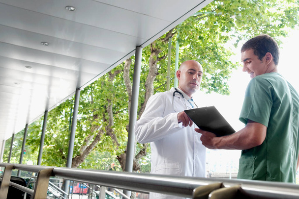 two doctors discussing on clipboard in hospital - Fotó, kép