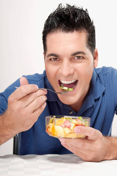 man eating a sandwich with a glass of fresh salad - Fotó, kép