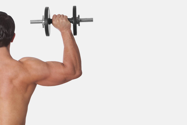 muscular man lifting weights on white background - Fotografie, Obrázek