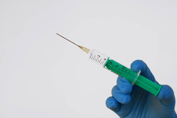 hand holding syringe with a white background - Фото, изображение