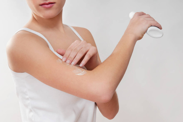 woman applying cosmetic lotion on white background - Φωτογραφία, εικόνα