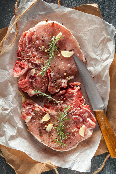 raw beef steak with rosemary and spices on a wooden board - Fotoğraf, Görsel