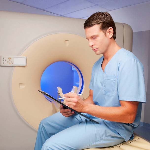male doctor sitting in hospital and looking at x-ray - Foto, immagini