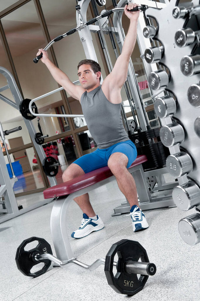 young man working out with dumbbells in gym - Foto, Imagem