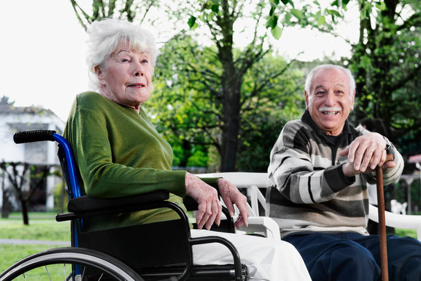 senior couple sitting on wheelchair and talking to disabled man - Fotoğraf, Görsel