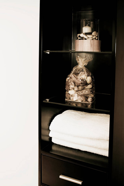white bath towels in a glass jar on a shelf - Fotó, kép