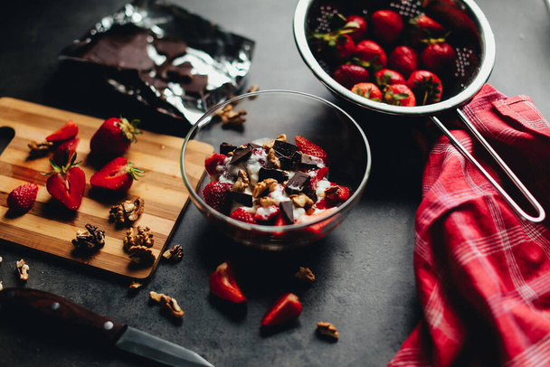 Składniki gotowania truskawki, czekolada, orzechy włoskie na stole. Wysokiej jakości zdjęcie - Zdjęcie, obraz