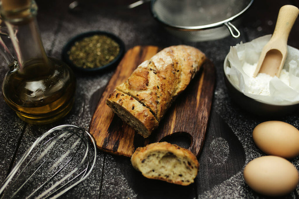 Fresh baked bread and baking ingredients on a table. High quality photo - Фото, зображення