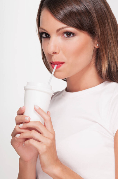 молодая женщина с чашкой кофе и молоком на белом фоне - Фото, изображение