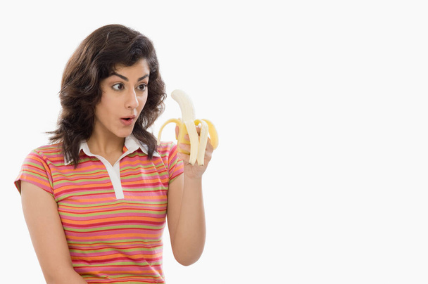 young woman holding a banana - 写真・画像